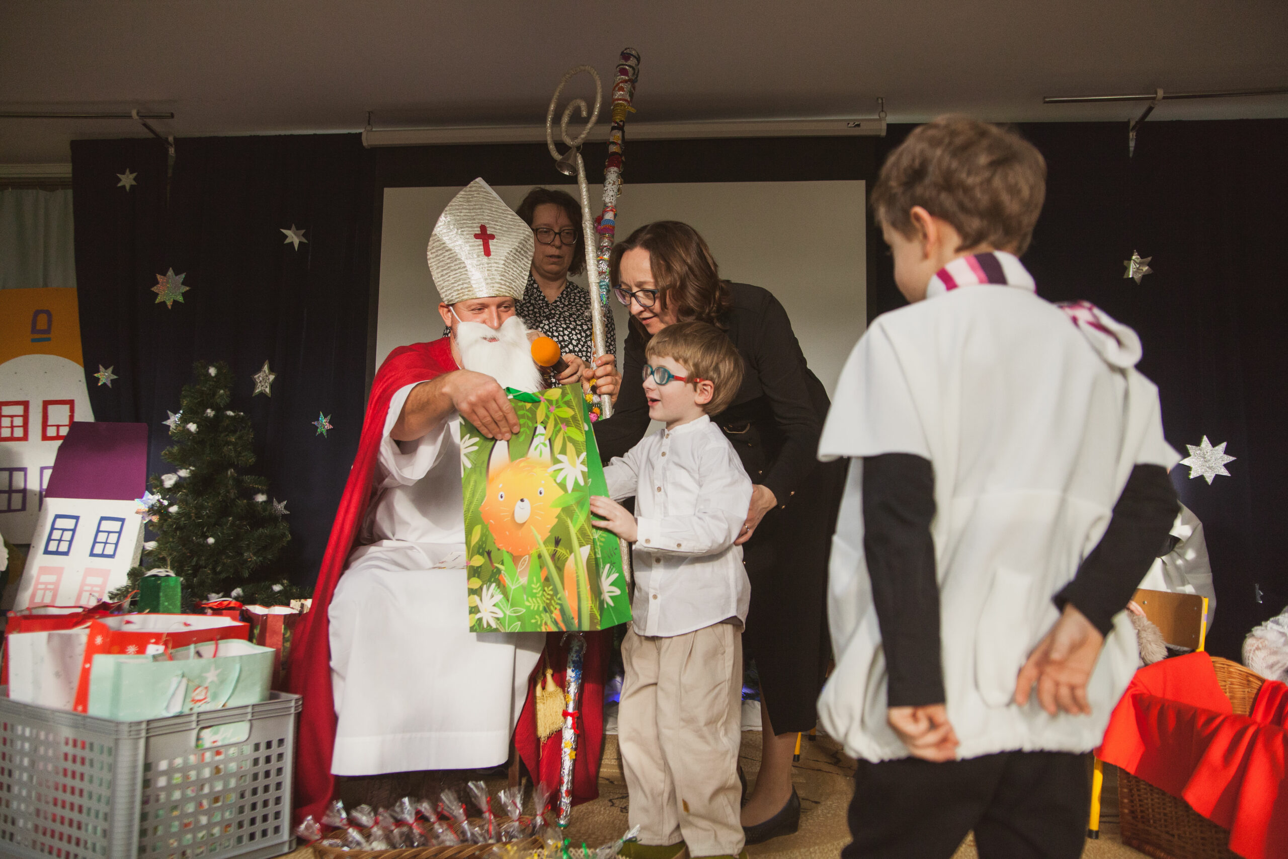 Mikołaj wręcza prezenty dzieciom.