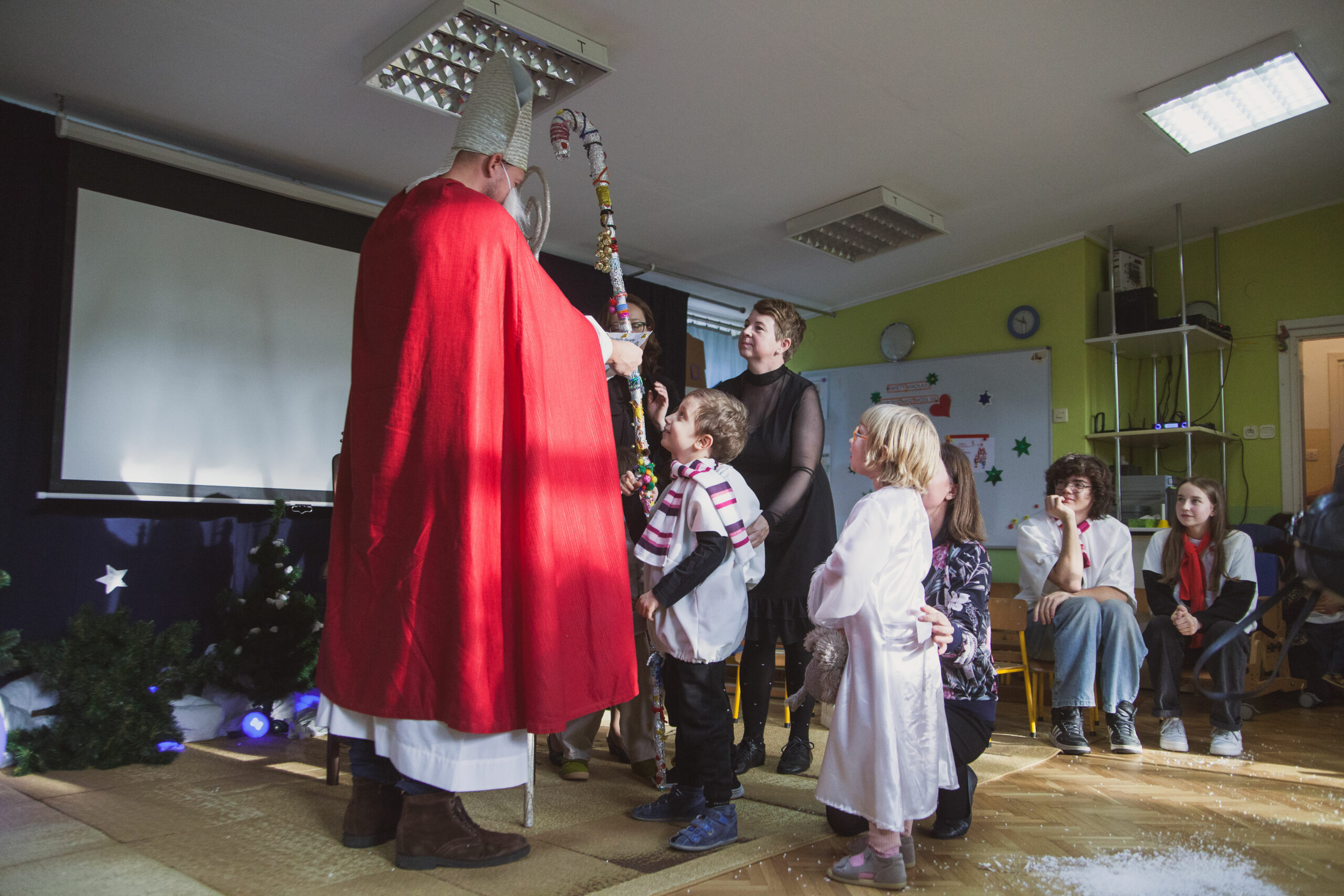 Mikołaj wręcza prezenty dzieciom.