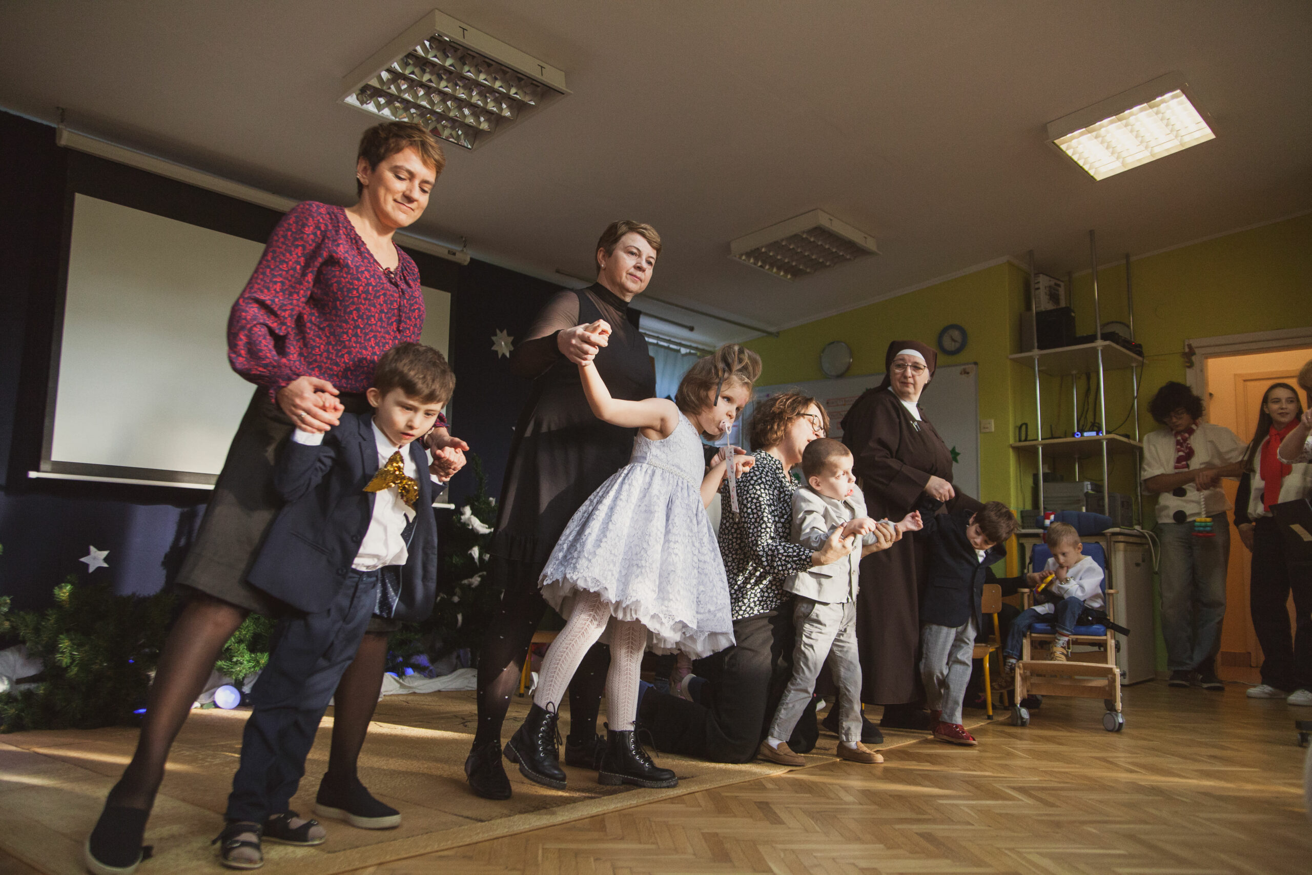 Przedszkolaki tańczą z nauczycielkami.