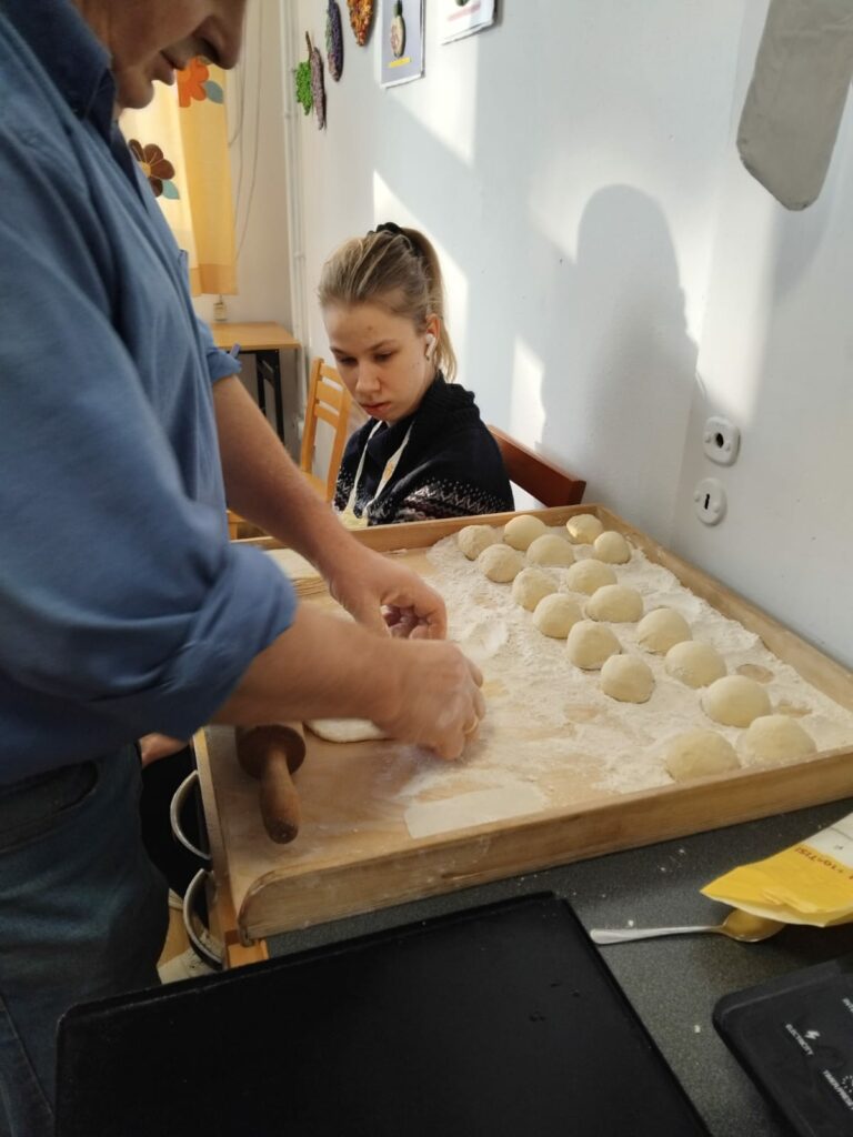 Pan Jarek układa bułki na stolnicy