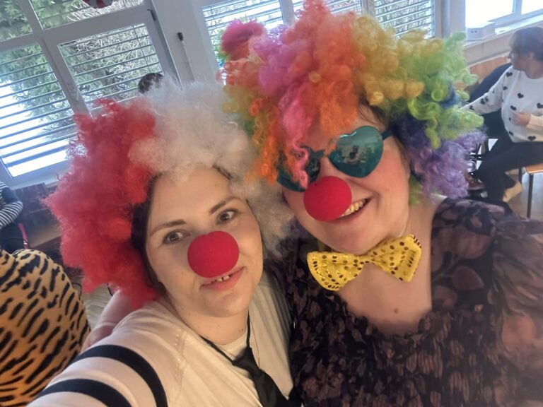 dwie nauczycielki w przebraniu klauna e sztucznymi czerwonymi nosami uśmiechnięte