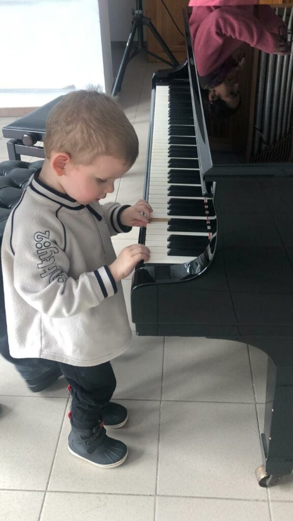 Chłopiec gra na fortepianie.
