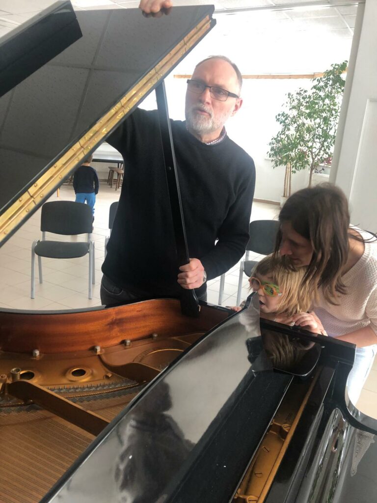 Pani nauczycielka z dziewczynką przy fortepianie.