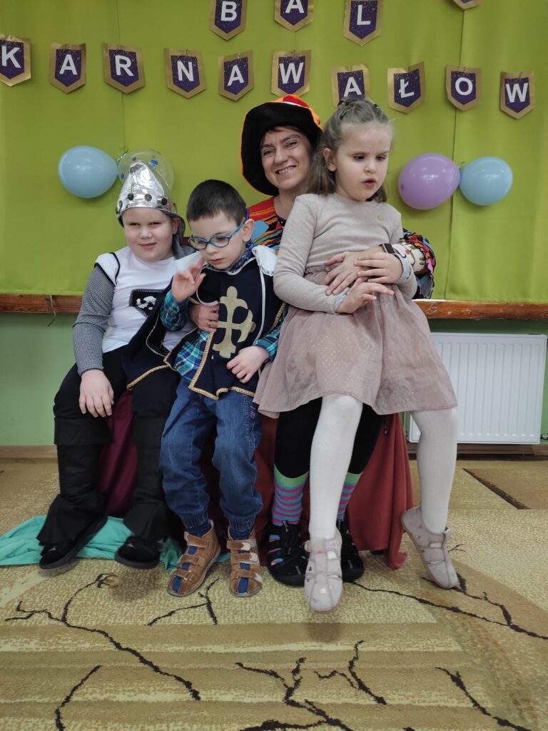 Grupa Krasnali na tle napisu Bal Karnawałowy.