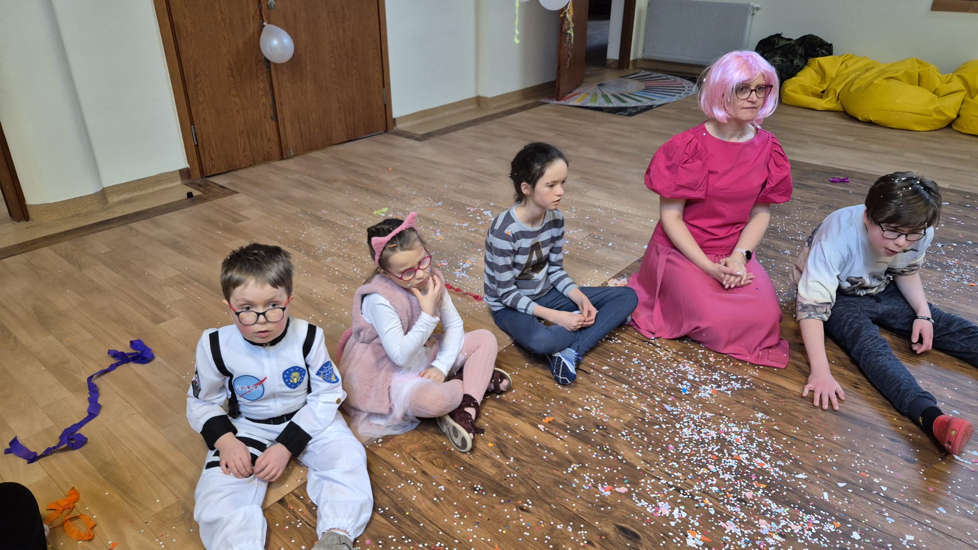 Uczniowie siedzą na podłodze podczas zabawy