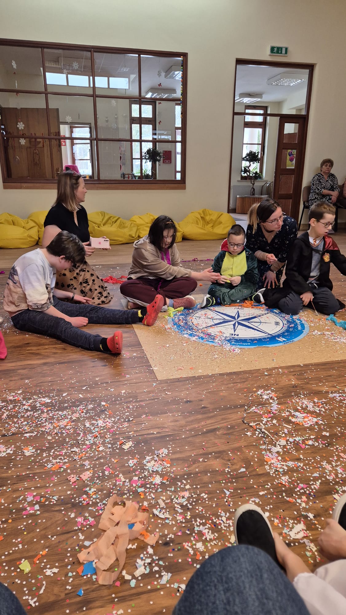 Uczniowie siedzący na podłodze