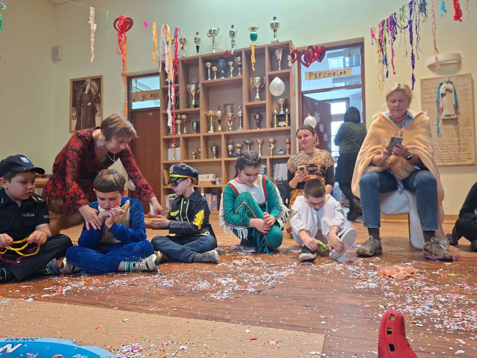 Uczniowie w kole siedzą na podłodze