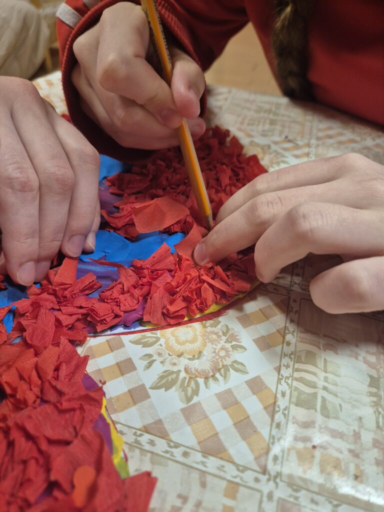 Julia z Pauliną wklejają czerwone bibułki