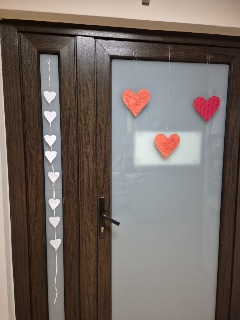 Drzwi w grupie 5 ozdobione czerwonymi sercami i białymi.