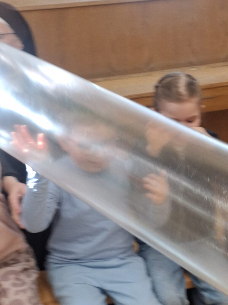 Dzieci oglądają ogromną napompowaną torbę foliową