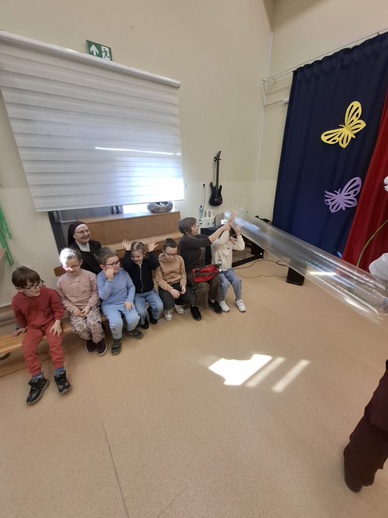 Pan dotyka dzieci napompowaną ogromną torbą foliową