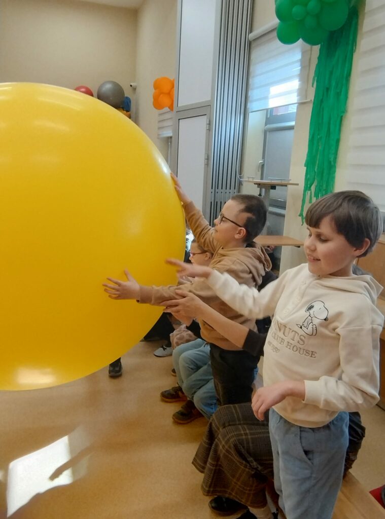 Dzieci dotykają wielkiego npompowanego balana