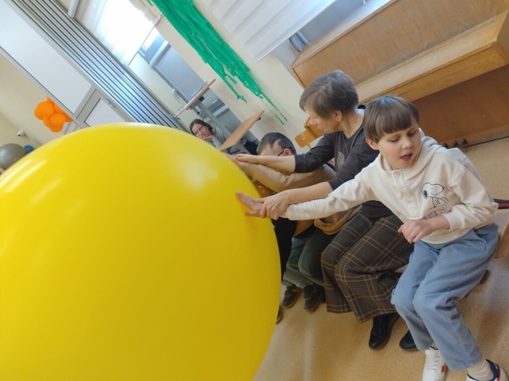 Pan pokazuje dzieciom duży balon