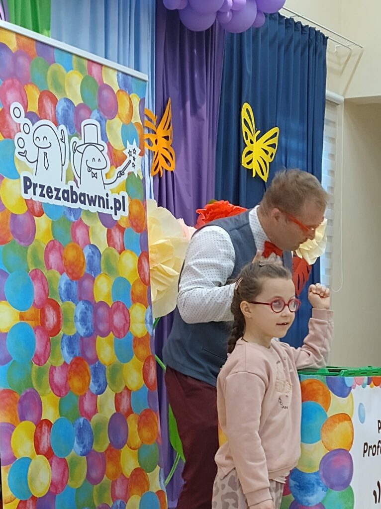 Dziewczynka razem z prowadzącym stoi na scenie