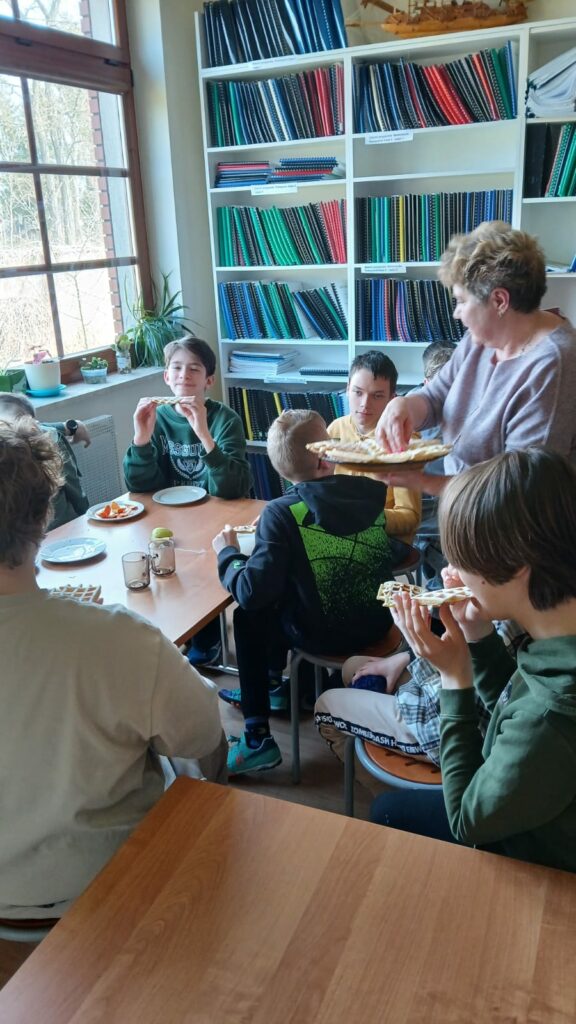 Pani częstuje starszych uczniów goframi