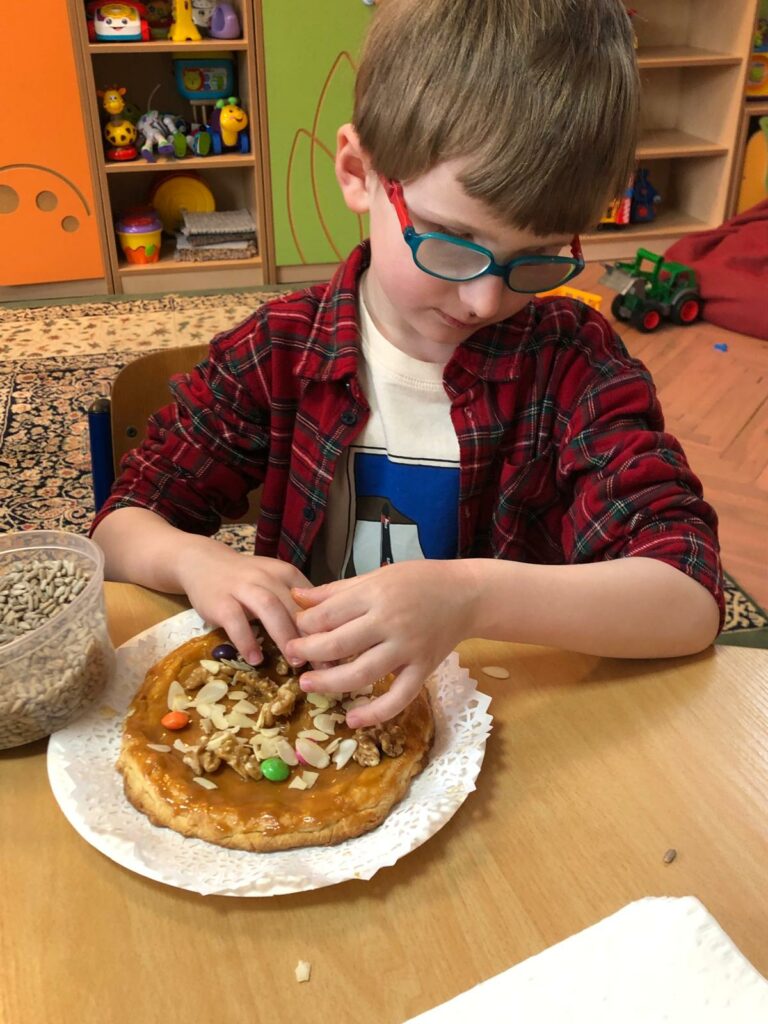 Chłopiec ozdabia mazurek