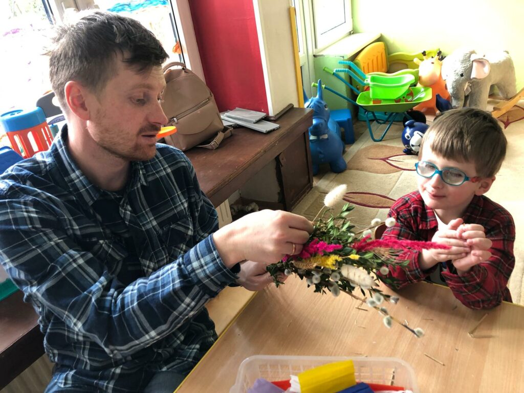 Chłopiec z tatą robią palmę.