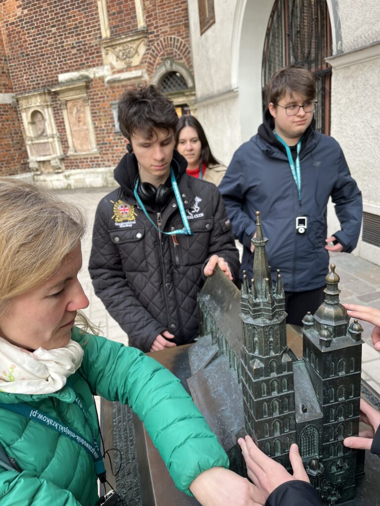Maturzyści wraz z opiekunką w skupieniu analizują detale architektoniczne kościoła na makiecie co stanowiło ciekawą lekcję historii sztuki.