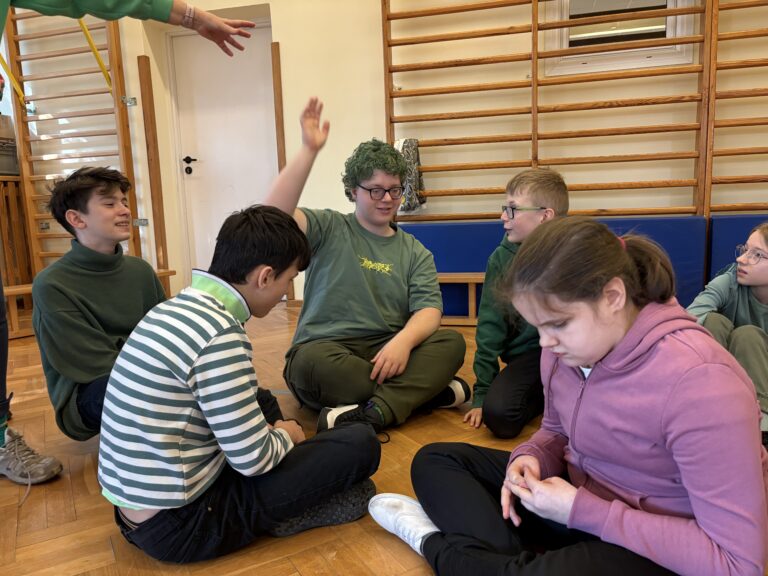 Uczniowie siedzący na podłodze