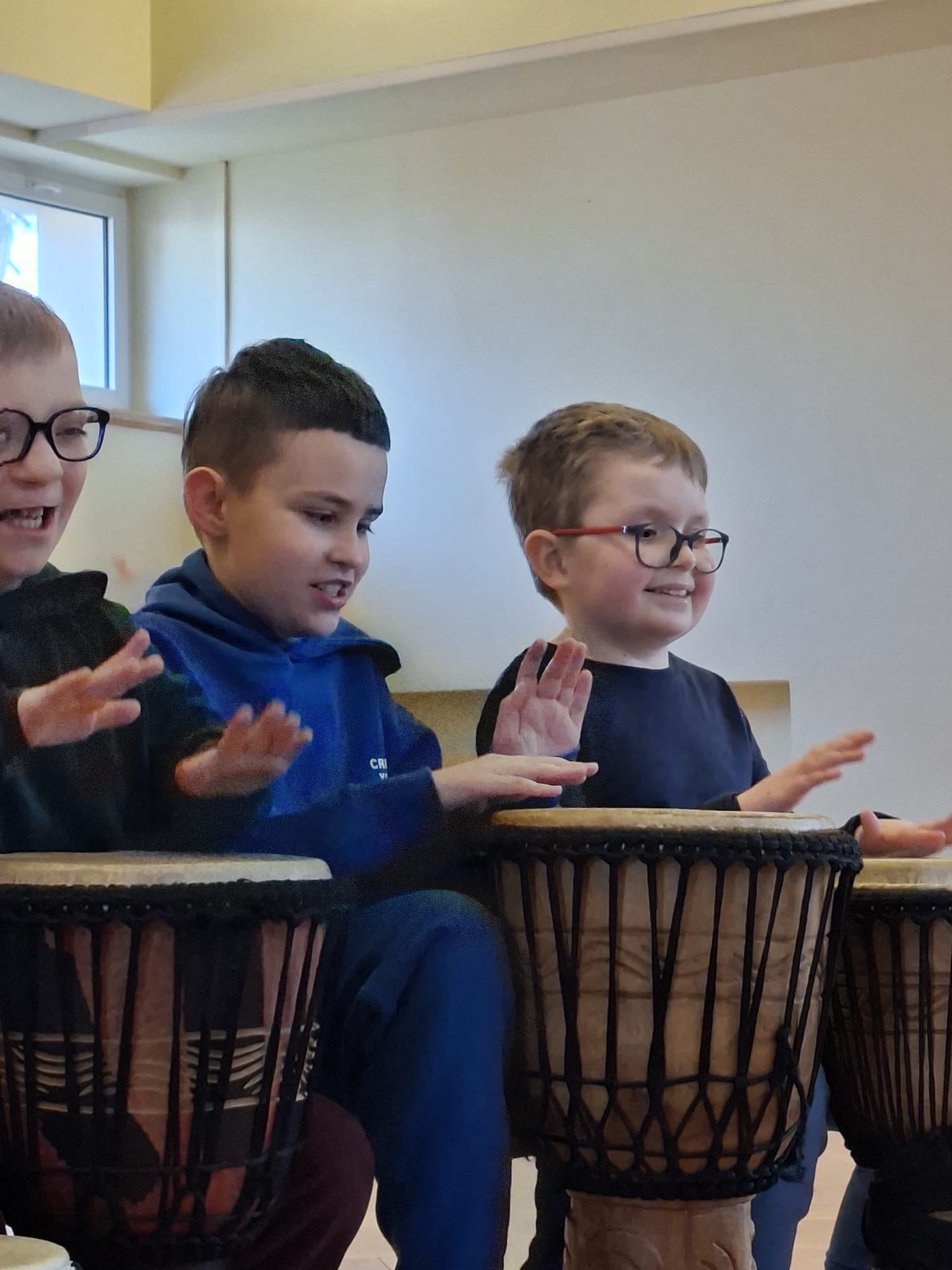 Trzech chłopców uderza w bębny