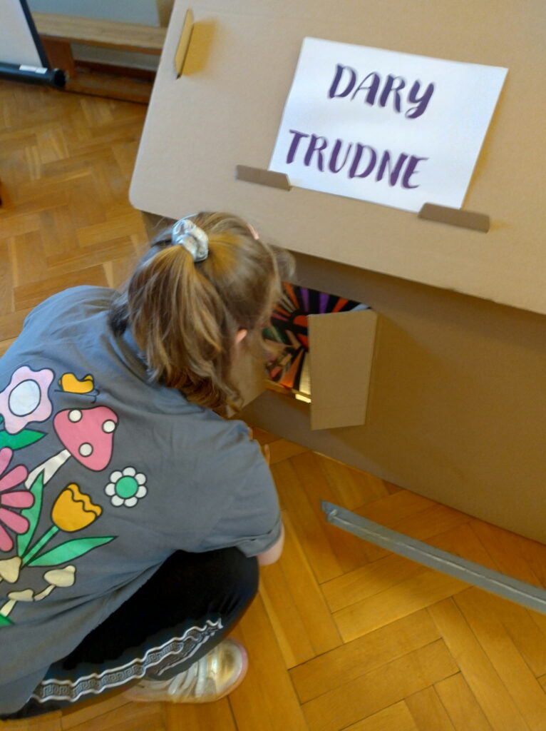 Uczennica oglądająca okno z podpisem dary trudne