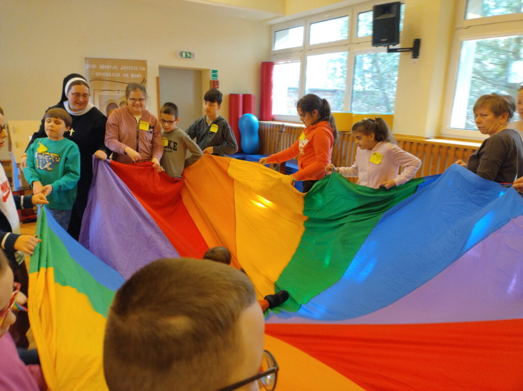 Uczniowie trzymający kolorową chustę animacyjną