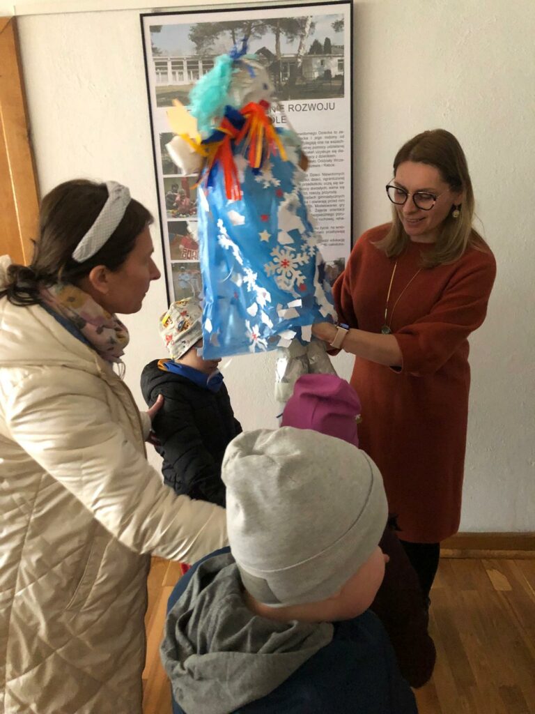 Dzieci wręczaą panią zimę Pani Dyrektor