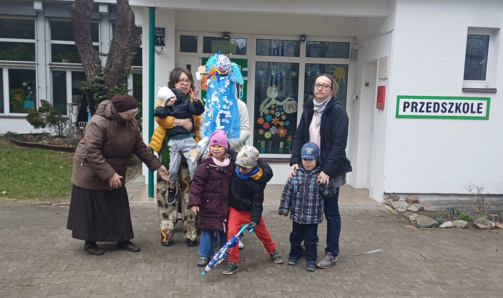 Dzieci z przedszkola z panią zimą - kukłą na patyku