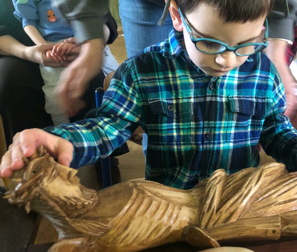 Chłopiec dotyka leżącej figury Pana Jezusa