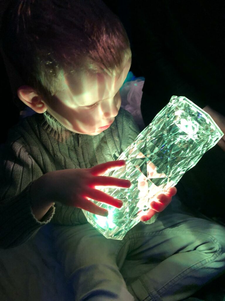 Chłopiec trzyma w rękach zapaloną lampę.