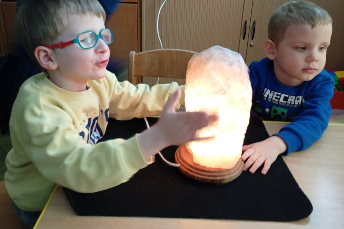Dwóch chłopców ogląda świecącą dużą lampkę solną
