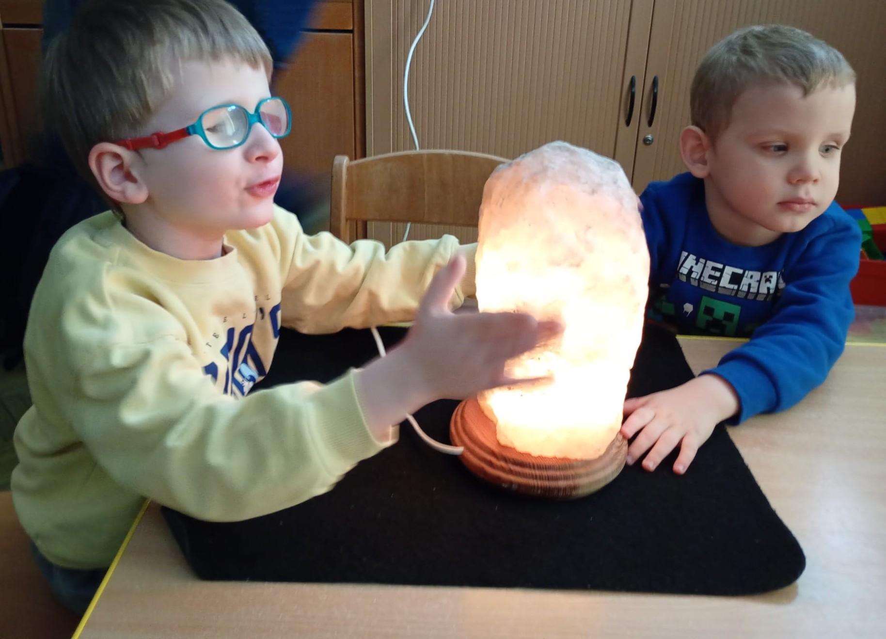 Dwóch chłopców ogląda świecącą dużą lampkę solną