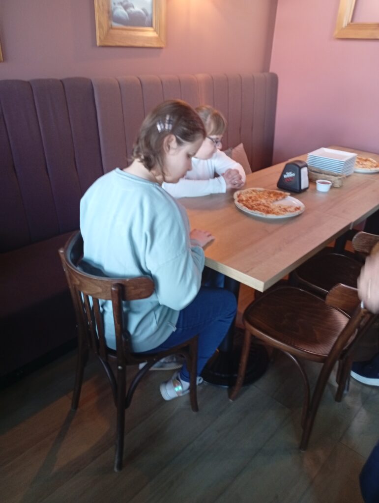 uczniowie jedzą pizzę