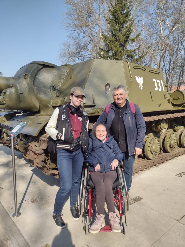 Uczennice wraz z opiekunem pozują do pamiątkowego zdjęcia na tle imponującego, historycznego działa samobieżnego ISU-152, które jest eksponatem plenerowej wystawy na terenie Cytadeli Warszawskiej.