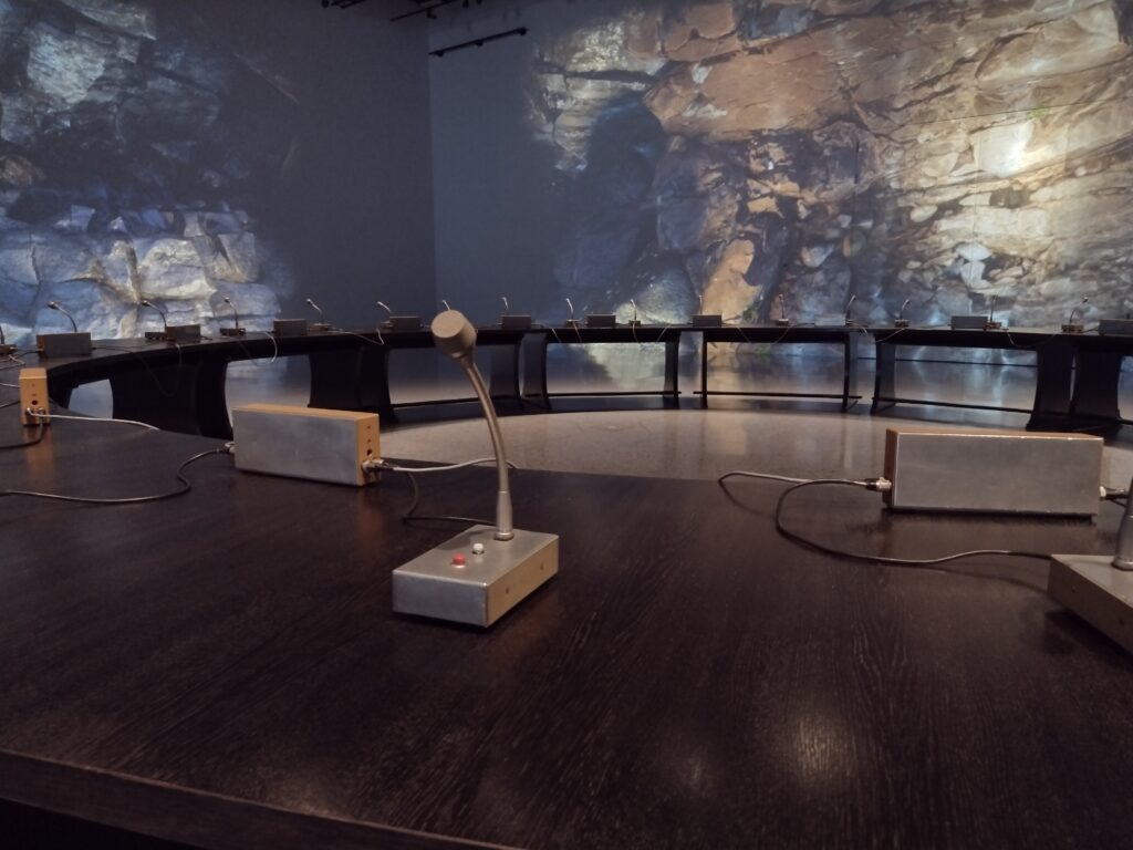 
Treść wiadomości Gemini
Zbliżenie na autentyczne mikrofony i pulpity rozmieszczone na blacie Okrągłego Stołu pozwala poczuć atmosferę historycznych obrad, które stały się symbolem pokojowego przejścia ustrojowego w Polsce.