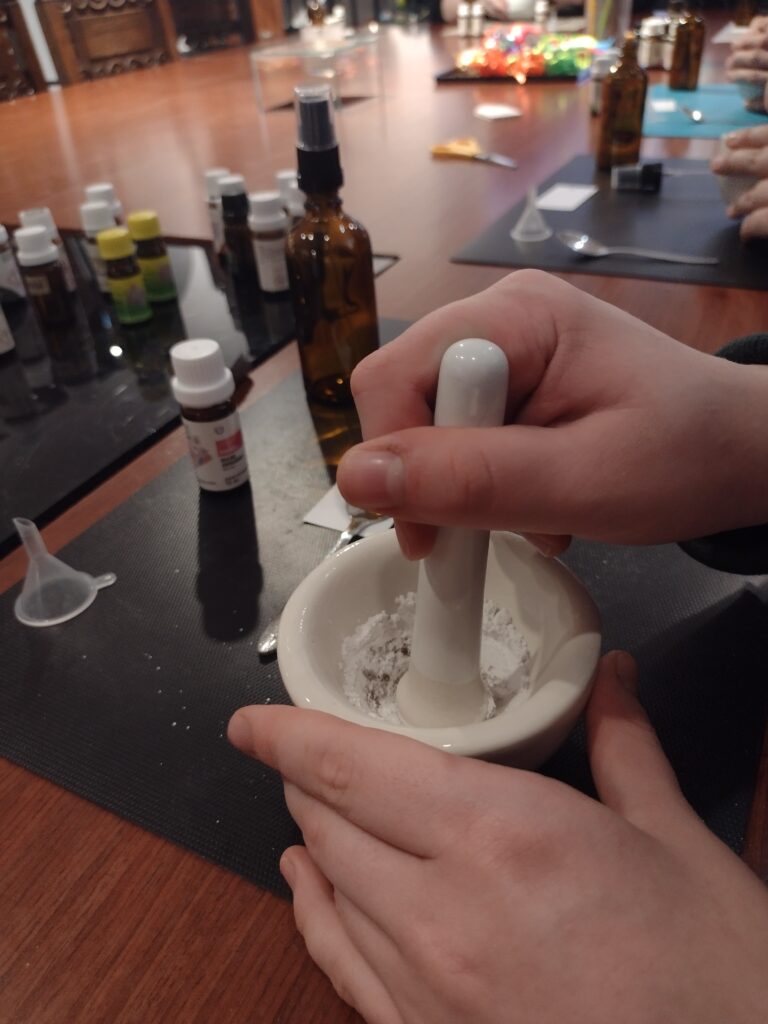 
Precyzyjne ucieranie składników w porcelanowym moździerzu to jeden z kluczowych etapów tworzenia bazy pod własną wodę zapachową, wymagający od uczniów cierpliwości i dokładności.