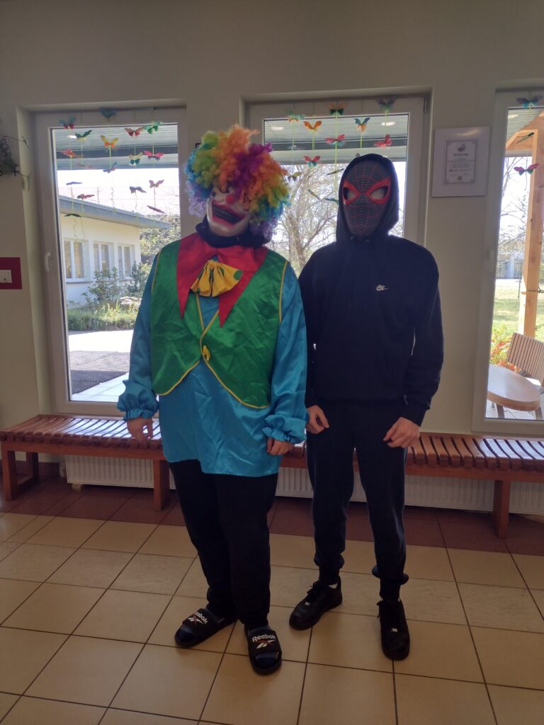 Zdjęcie przedstawia dwóch uczniów przebranych za klauna oraz Spider-Mana, którzy w ramach szkolnej akcji „Literackie przebieranki” wspólnie świętują Światowy Dzień Książki i Praw Autorskich.