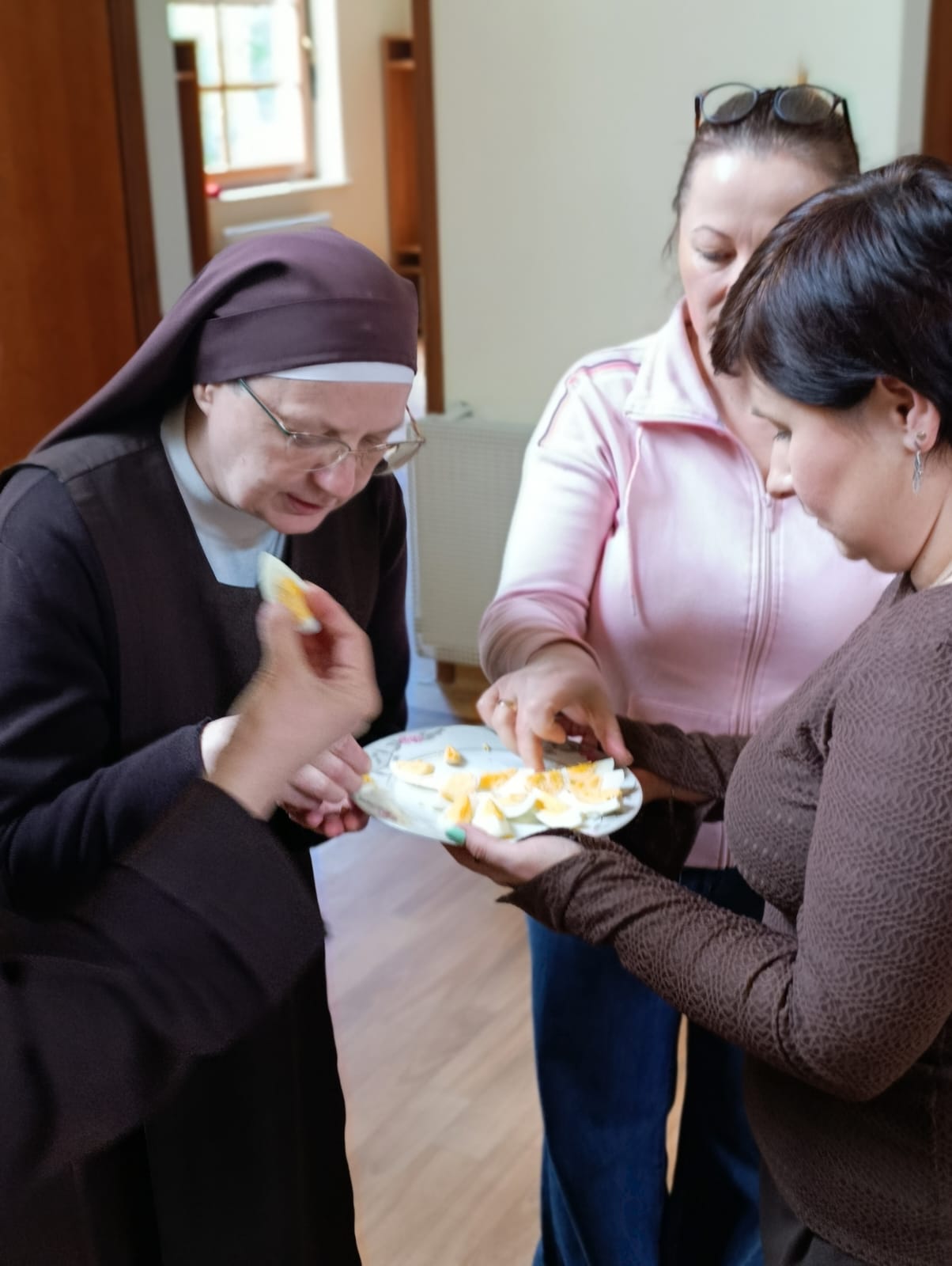 Pani dyrektor częstująca jajkiem siostrę Maristellę