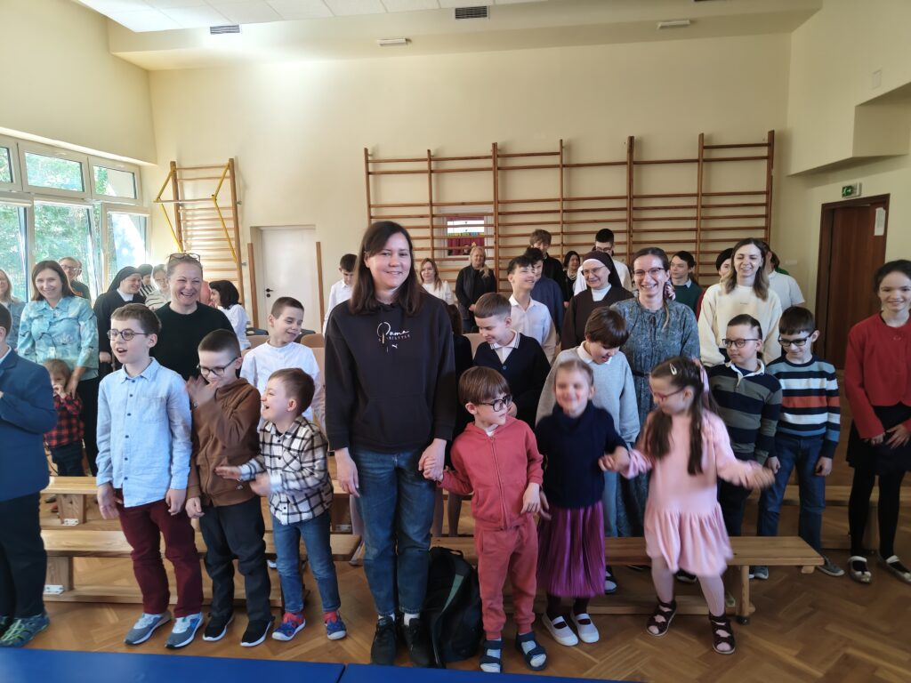 Roześmiana widownia śpiewa Sto lat dla szkoły