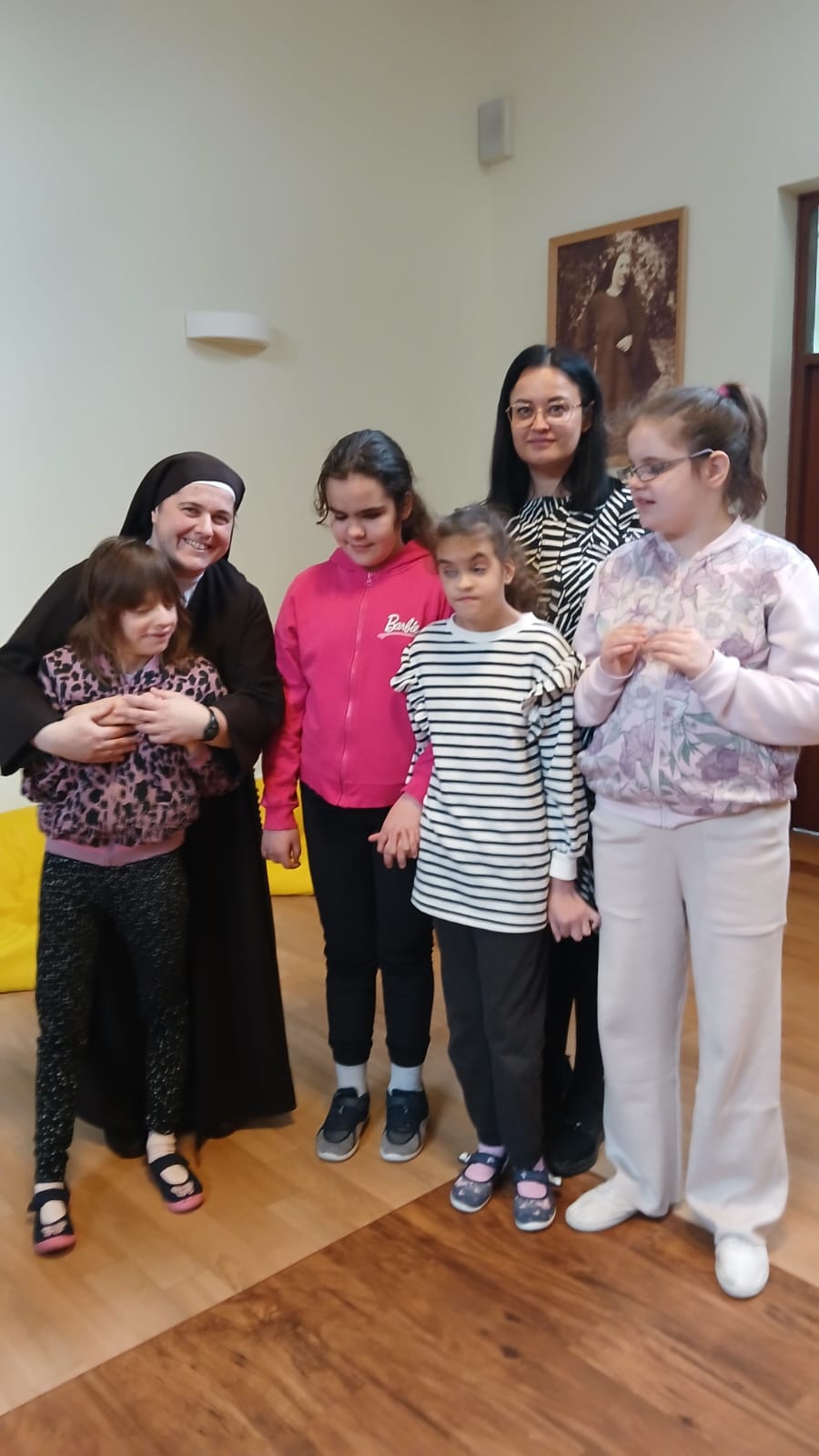 Uczennice, siostra zakonna i nauczycielka pozują do zdjęcia