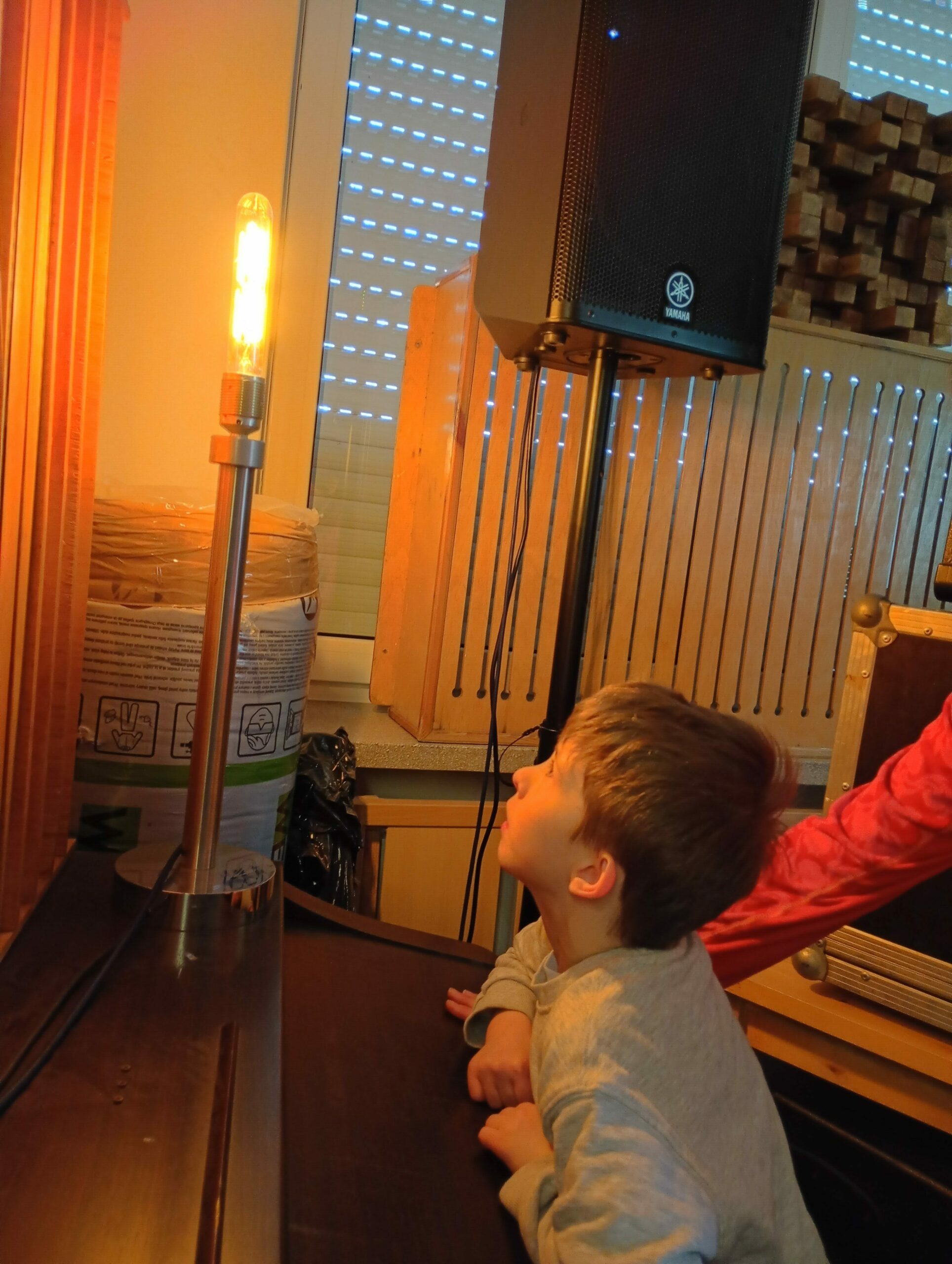 Chłopiec wpatruje się w stojącą na blacie lampę