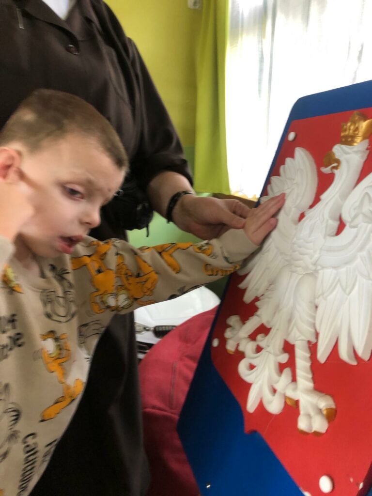 Chłopiec ogląda wypukłe godło Polski.