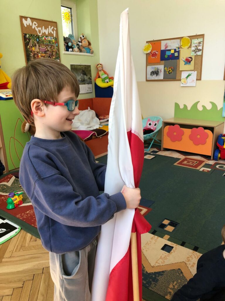 Chłopiec trzyma flagę Polski.