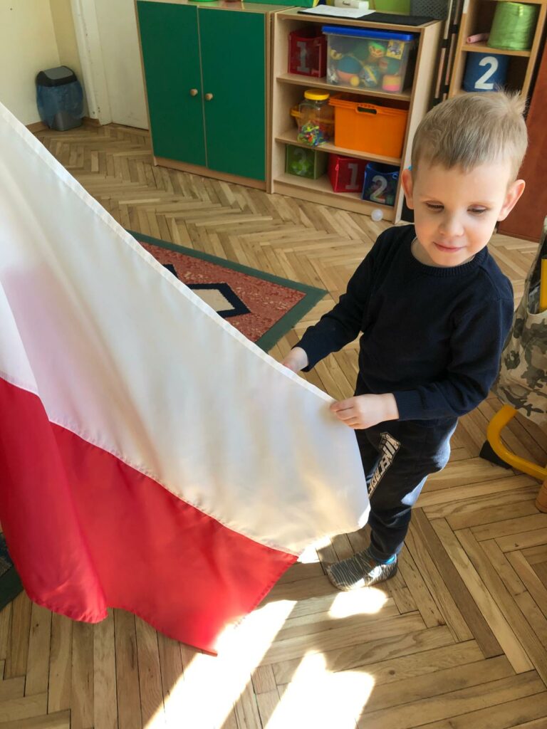 Chłopiec trzyma flagę Polski.