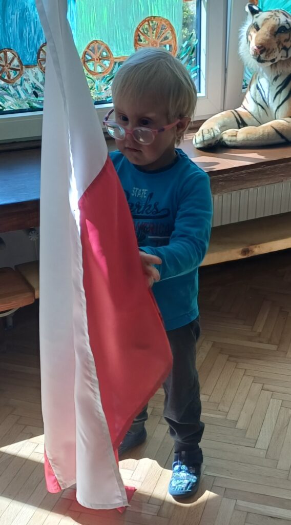 Chłopiec trzyma flagę Polski.