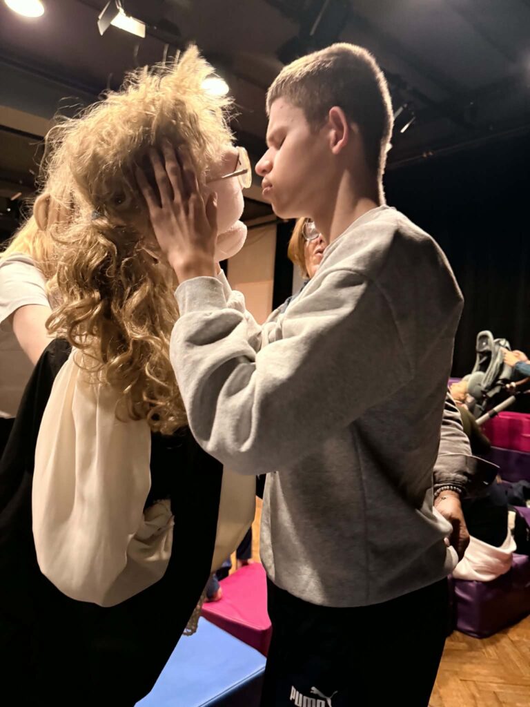Uczeń podczas warsztatów dotyka twarzy dużej lalki teatralnej i poznaje ją poprzez bezpośredni kontakt.